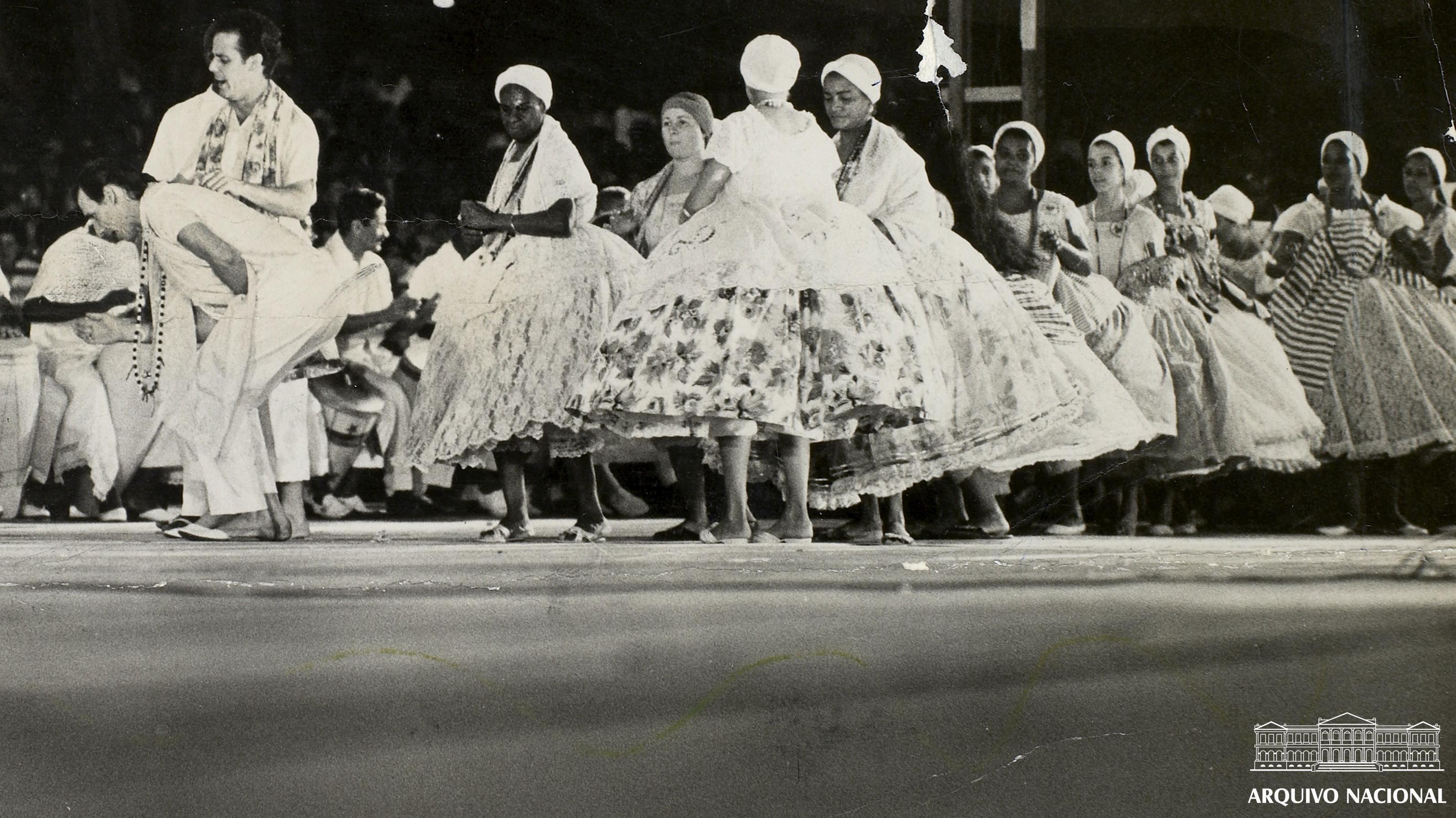 Cerimônia de umbanda realizada ao ar livre no Rio de Janeiro em 1971, com pessoas vestidas de branco formando um círculo em torno de um altar com velas e objetos religiosos