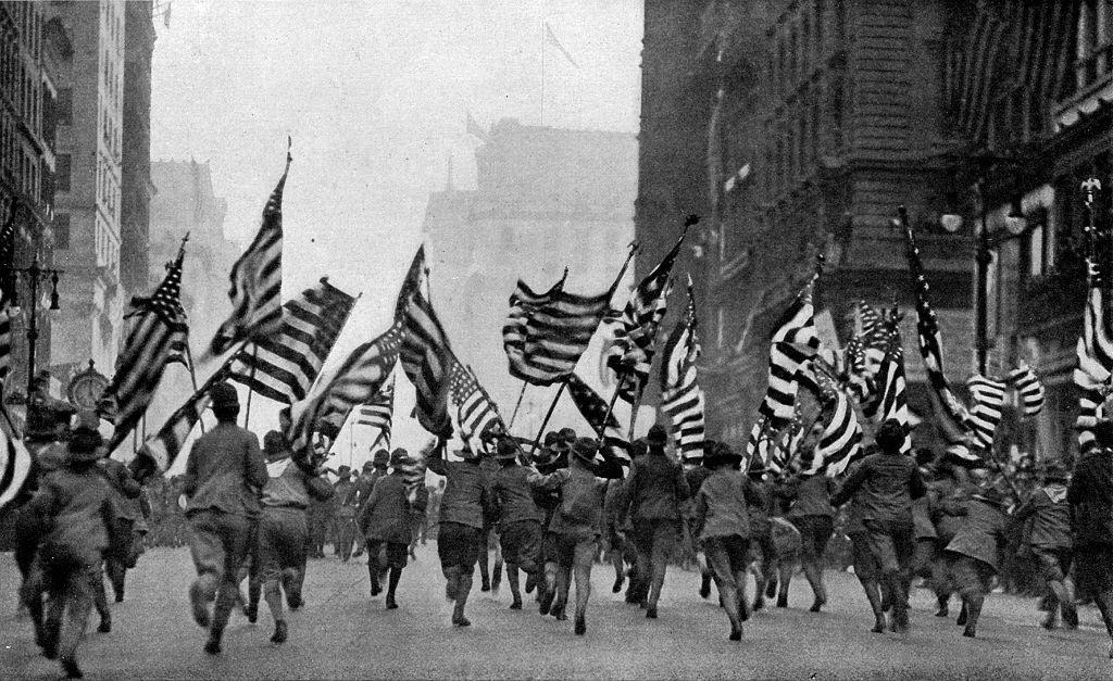 Uniformados estadounidenses corren enarbolando banderas de su país por una calle de Nueva York, en una imagen de 1917. 