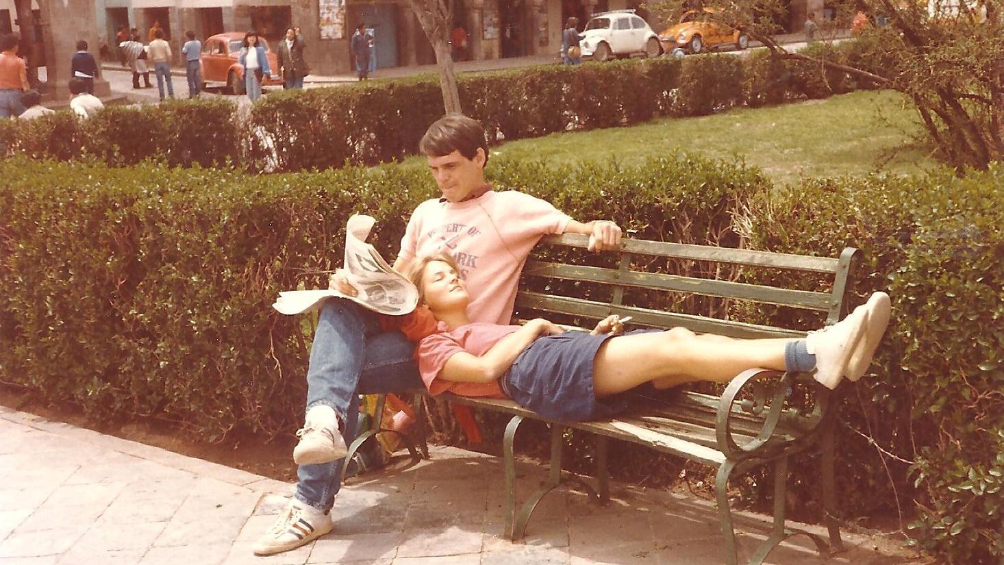 Sobre un asiento en lo que parece ser una plaza, Willem está sentado con las piernas cruzadas y lee el periódico. En su regazo, Annette posa su cabeza con los ojos cerrados.