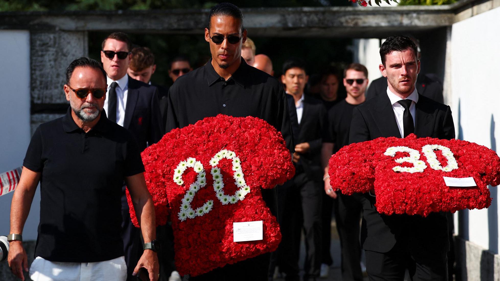 Virgil van Dijk y Andrew Robertson llevan coronas de flores con los números 20 y 30