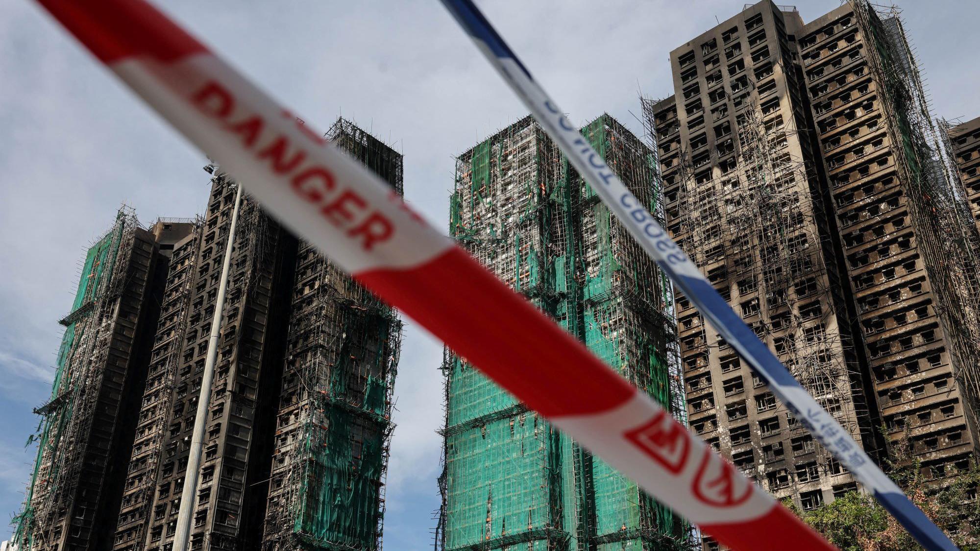 Police cordons are placed at the scene of the Wang Fuk Court housing estate fire as mourners pay tribute to the victims, in Tai Po, Hong Kong, China, November 28, 2025.