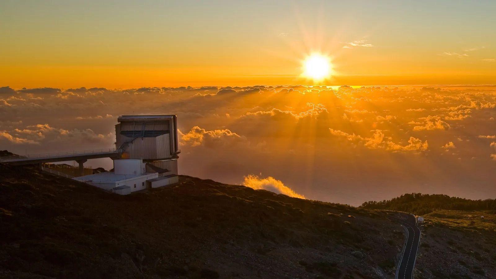 La instalación, en una montaña, con nubes, al atardecer