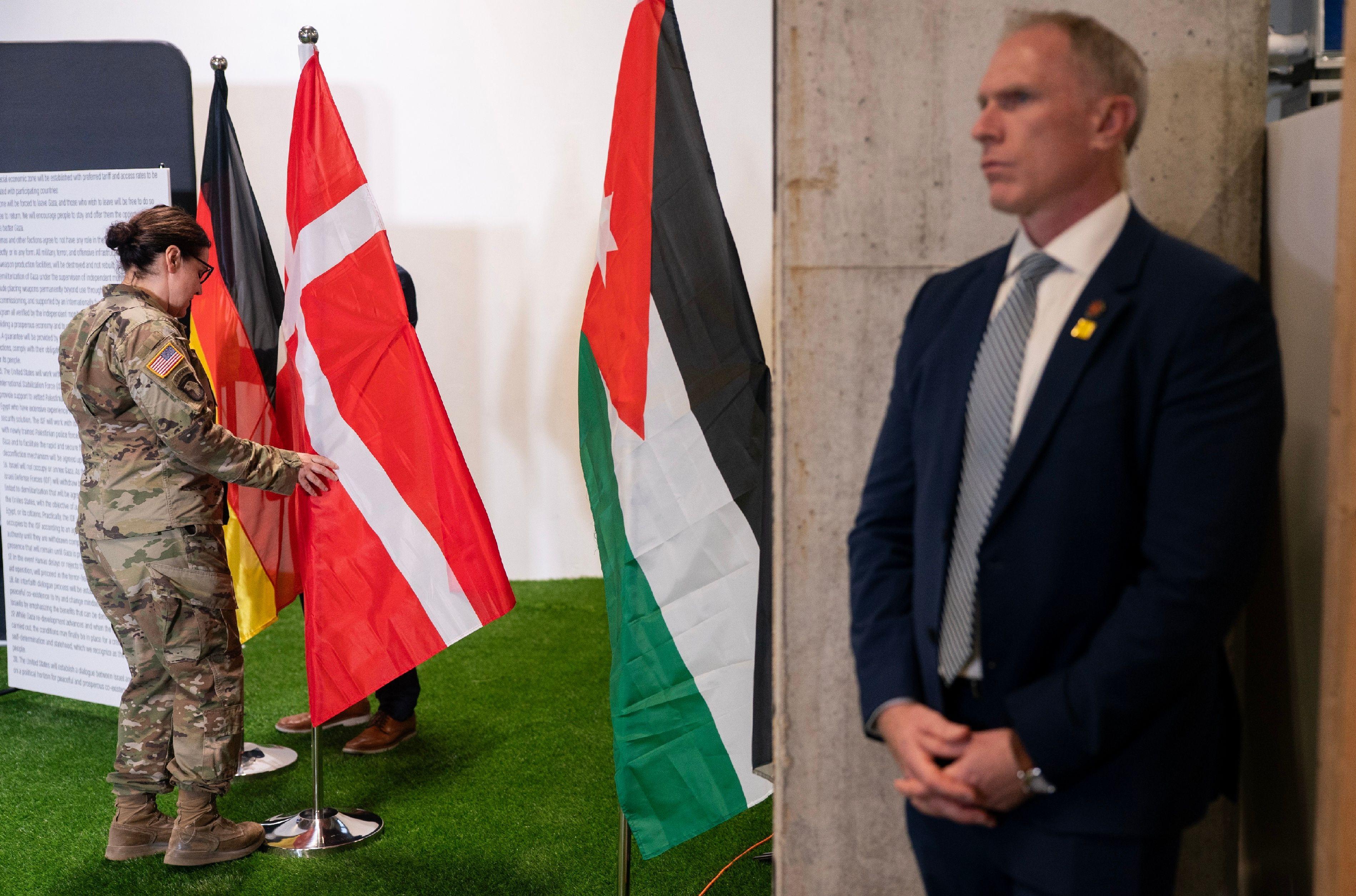 جندي أمريكي يجهّز الأعلام قبل مؤتمر صحفي لنائب الرئيس جي دي فانس في كريات غات، إسرائيل.