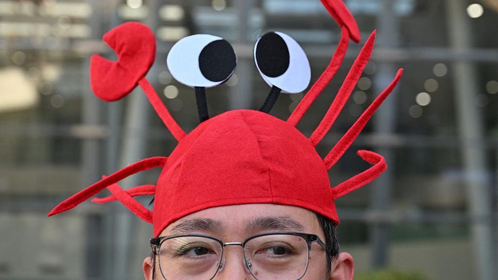 2026年3月11日，在北京百度總部，一名男子戴著印有開源人工智慧助理OpenClaw標誌的龍蝦帽。 