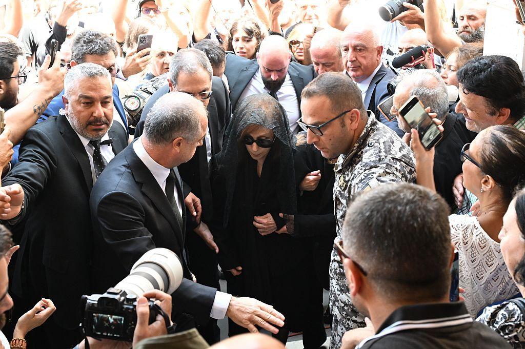 فيروز وسط حشد من المعزين برحيل زياد الرحباني وعدسات الكاميرات تحيط بها.