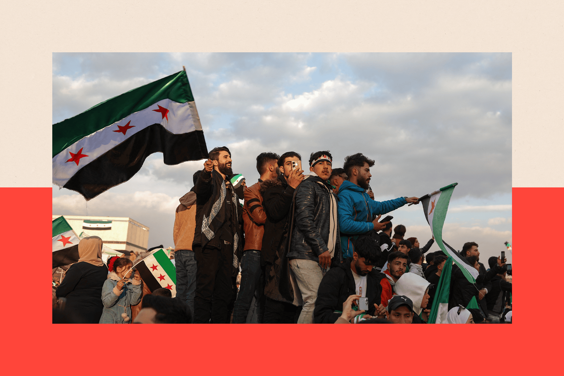 People wave flags during celebrations for the ousting of president Bashar al-Assad 
