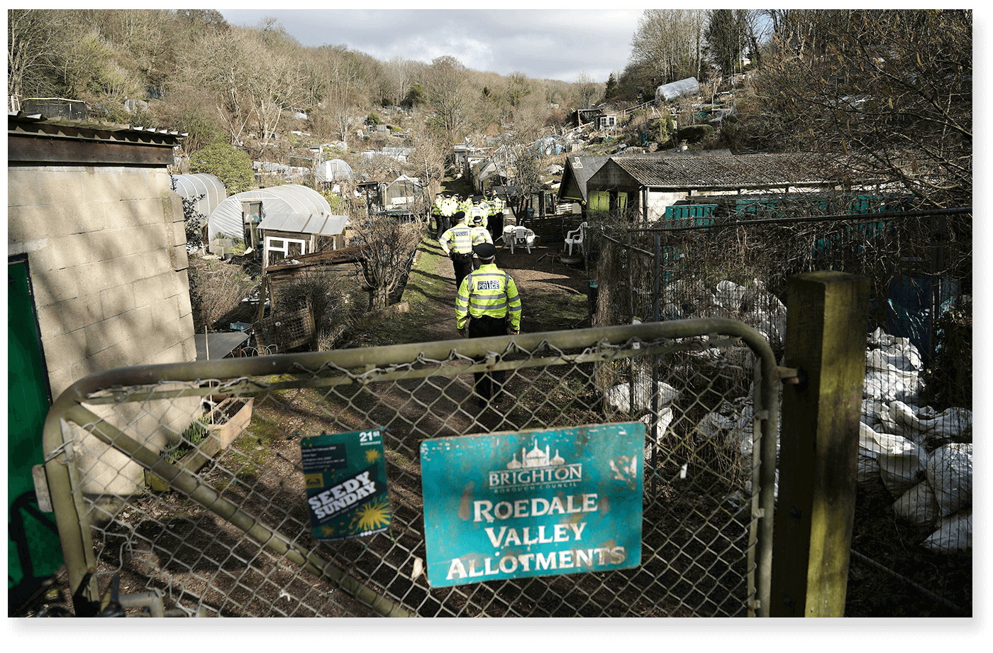 Policiais dentro de terreno cercado por grades, onde ficava o galpão