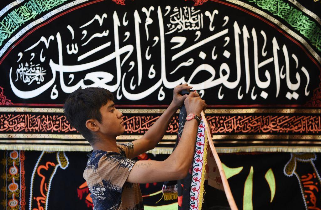 In this photograph taken on September 25, 2017, an Afghan young Shiite boy displays religious flags ahead of Ashura along a roadside in Kabul.