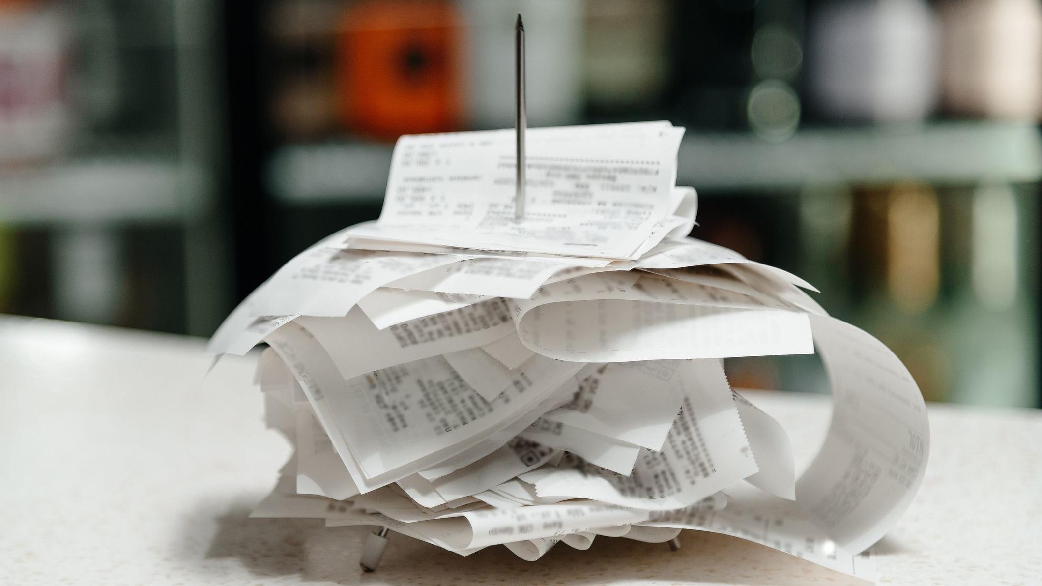 Notas fiscais empilhadas, após serem perfuradas em espeto de metal