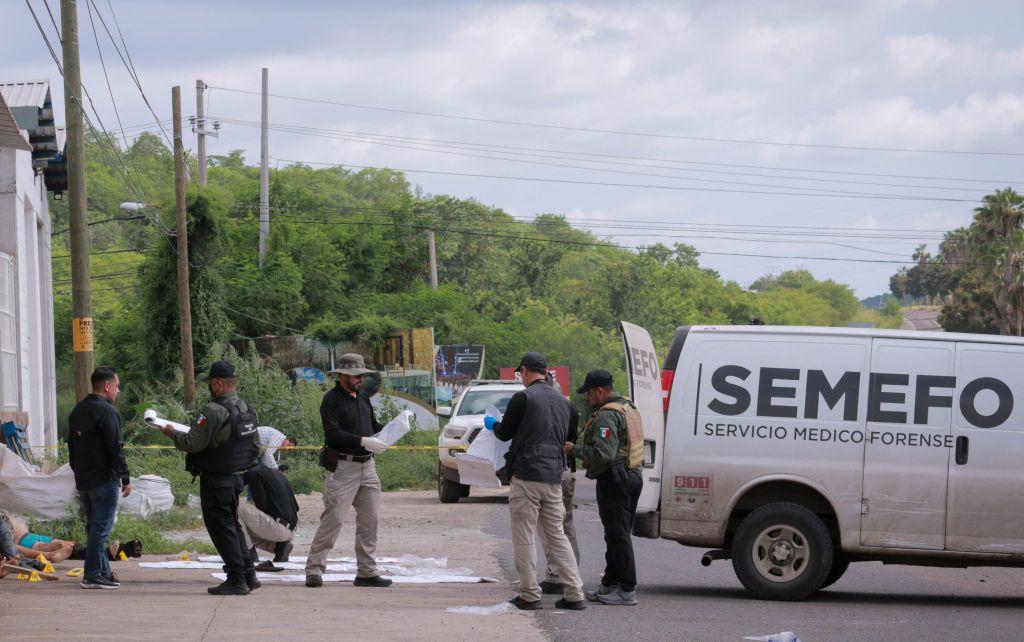 Trabajadores forenses junto a cuerpos sin vida en Culiacán