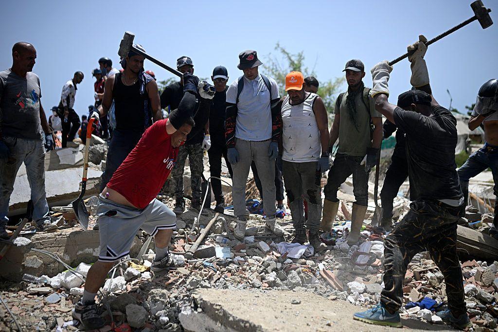 Voluntarios golpean restos de concreto con mazos de hierro buscando sobrevivientes bajo los escombros en La Guaira, Venezuela, 26 de junio 2026