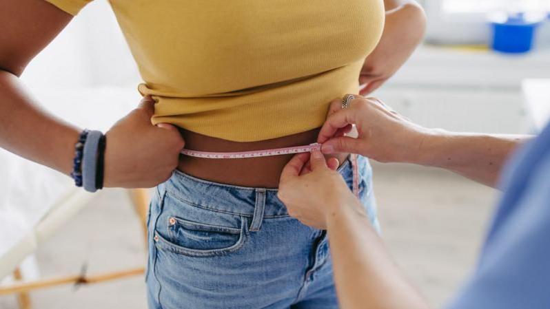 Mujer a la que le miden la cintura
