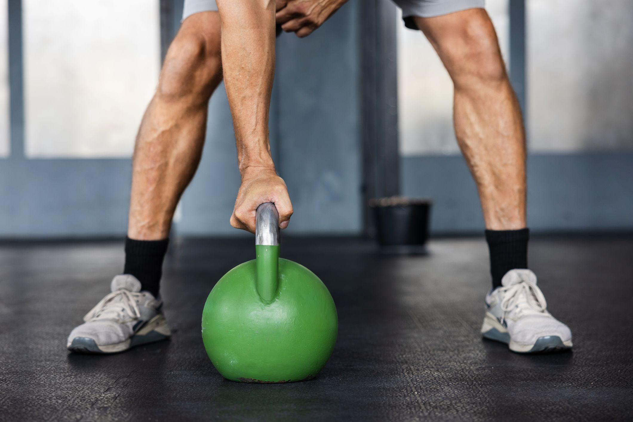 Un hombre levanta una pesa en el gimnasio. 