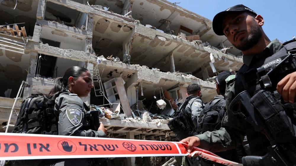 Policía israelí frente a un bloque destruido.