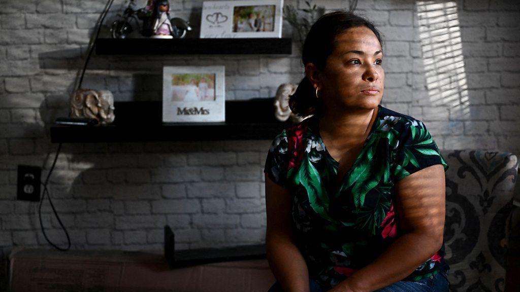 Mulher na sala de estar, olhando para a janela