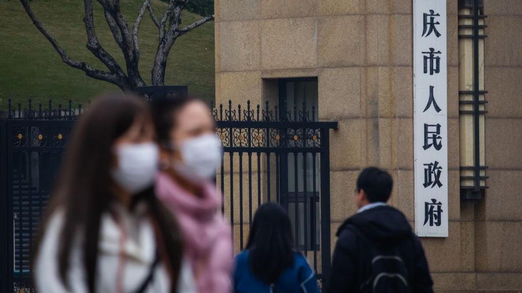 Mulheres de máscara caminham na rua