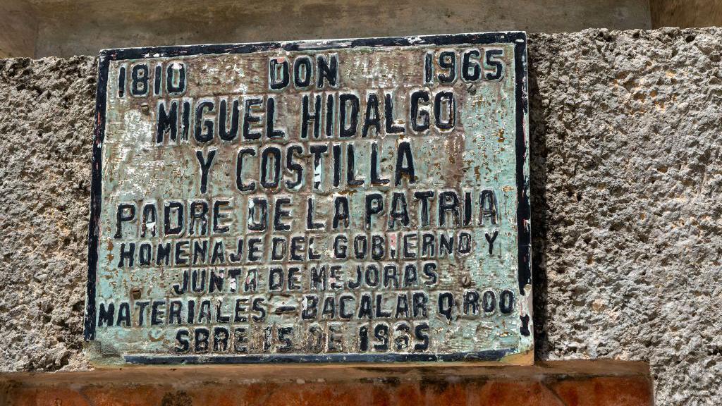 Una placa vieja y desgastada reconoce a Miguel Hidalgo como "Padre de la Patria".