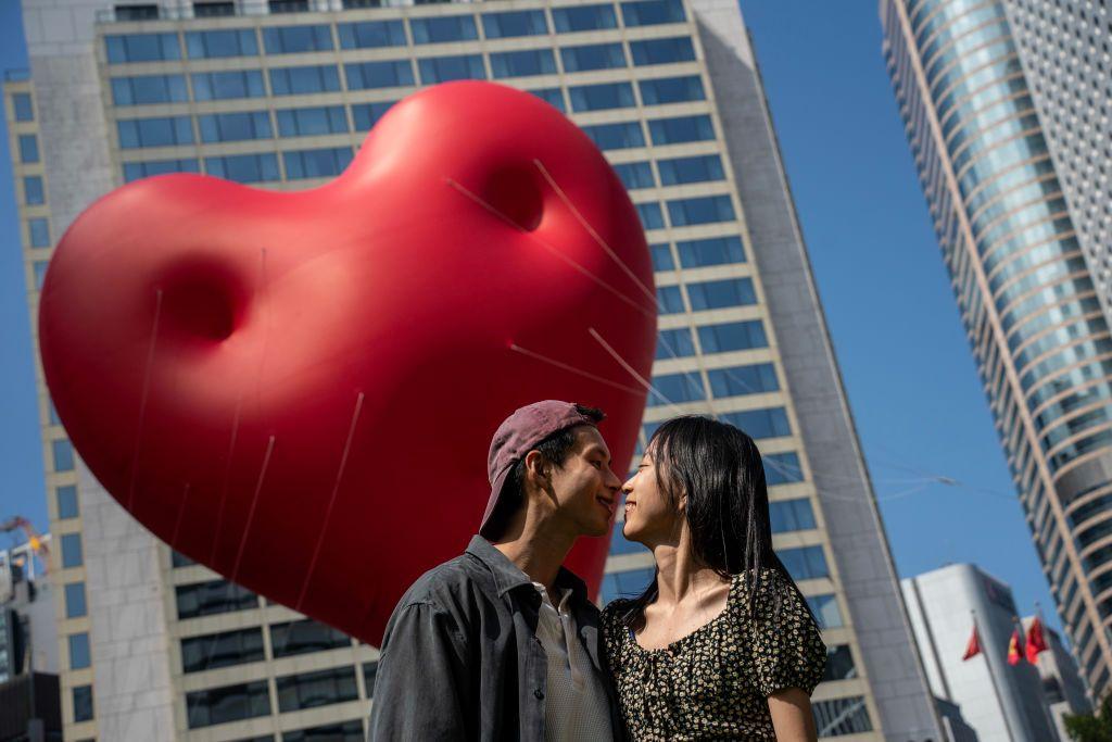 2023年2月14日，一對年輕情侶站在心型氣球前。