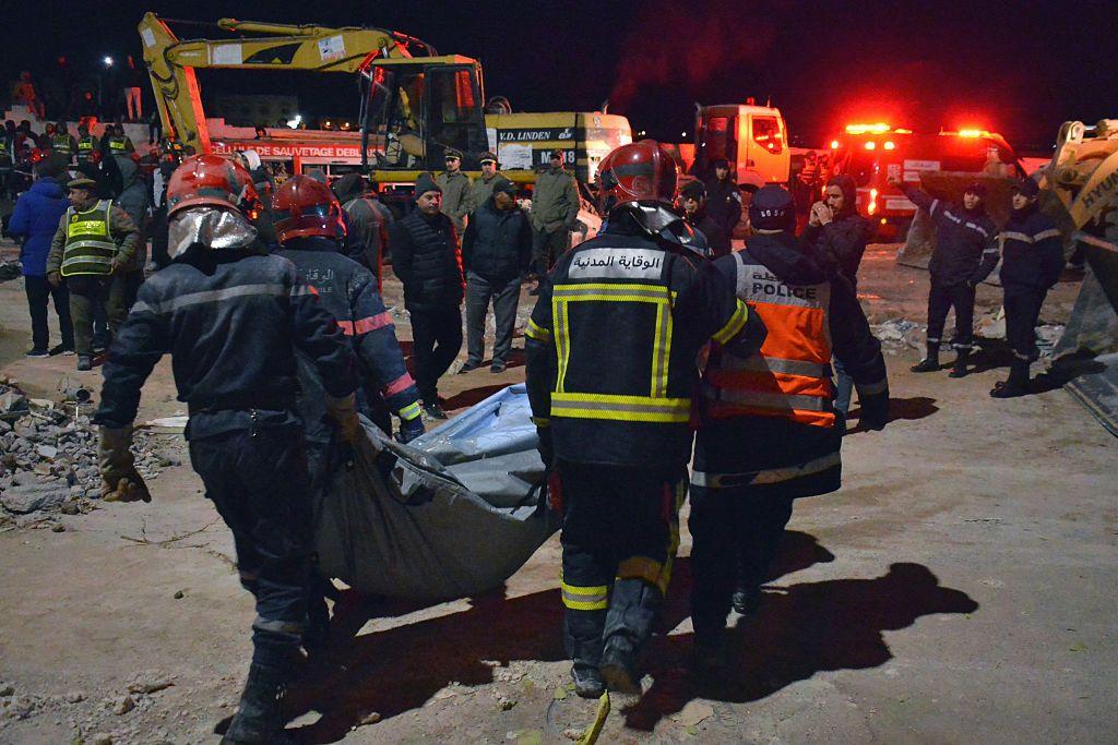 رجال الإنقاذ يحملون جثة أحد الضحايا خلال عملية إنقاذ بعد انهيار مبنيين في مدينة فاس