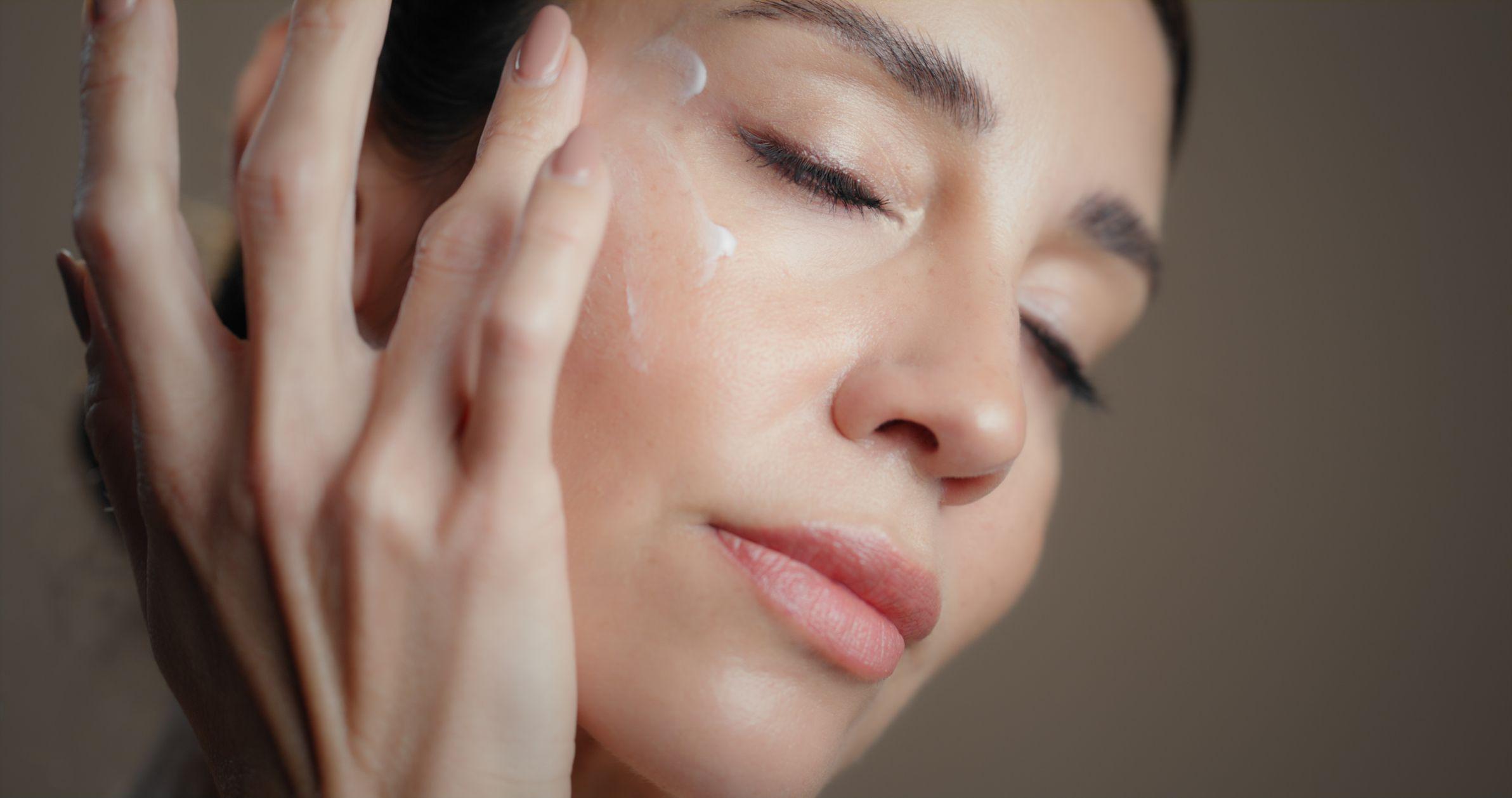 Mujer aplicándose crema en la cara