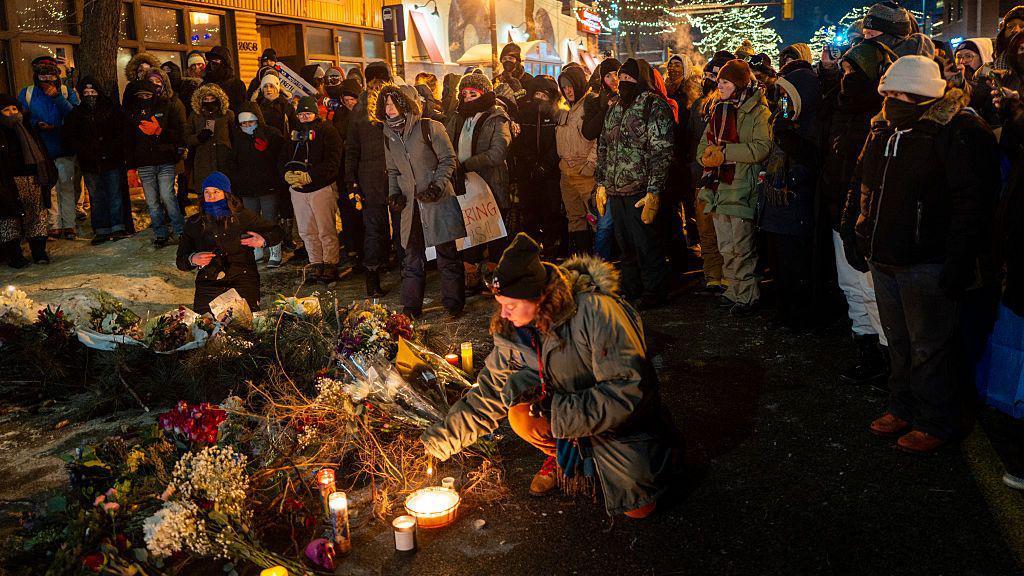 Personas colocan arreglos florales en el suelo, así como velas, para honrar la memoria de alex pretti. 