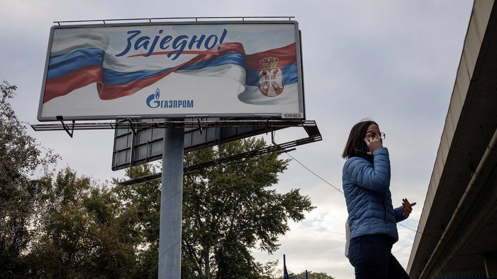 sankcije nis-u, nis, američke sankcije nis, devojka prolazi pored bilborda