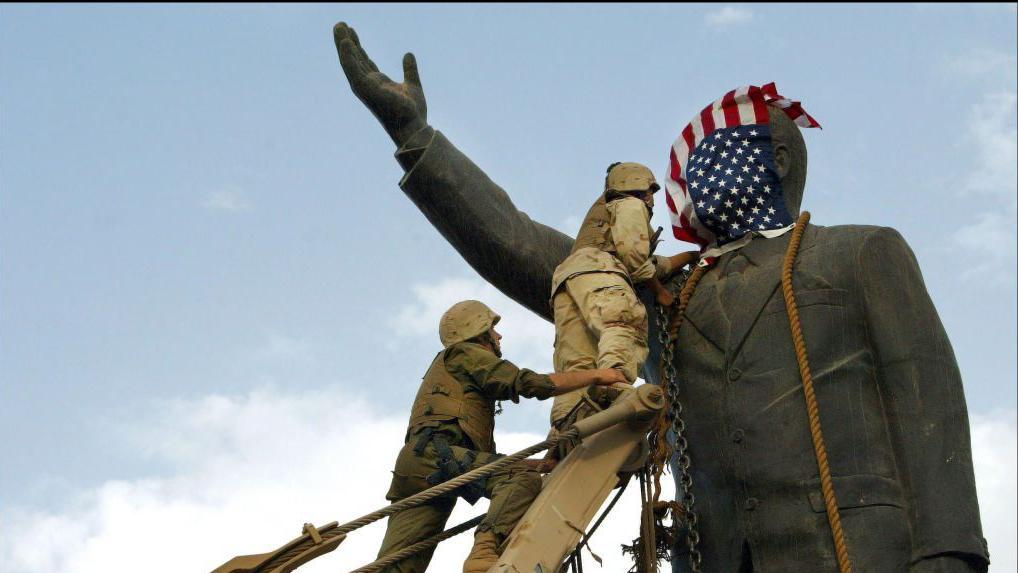 Soldados de EEUU colocan una bandera de su país a una estatua de Sadam Hussein en Irak en 2003.