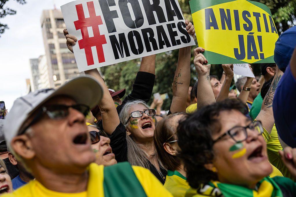 Apoiadores do ex-presidente Jair Bolsonaro seguram cartazes contra o ministro do STF Alexandre de Moraes e a favor da anistia aos condenados pelas invasões do 8 de janeiro durante ato na Avenida Paulista, em São Paulo, em 3 de agosto de 2025