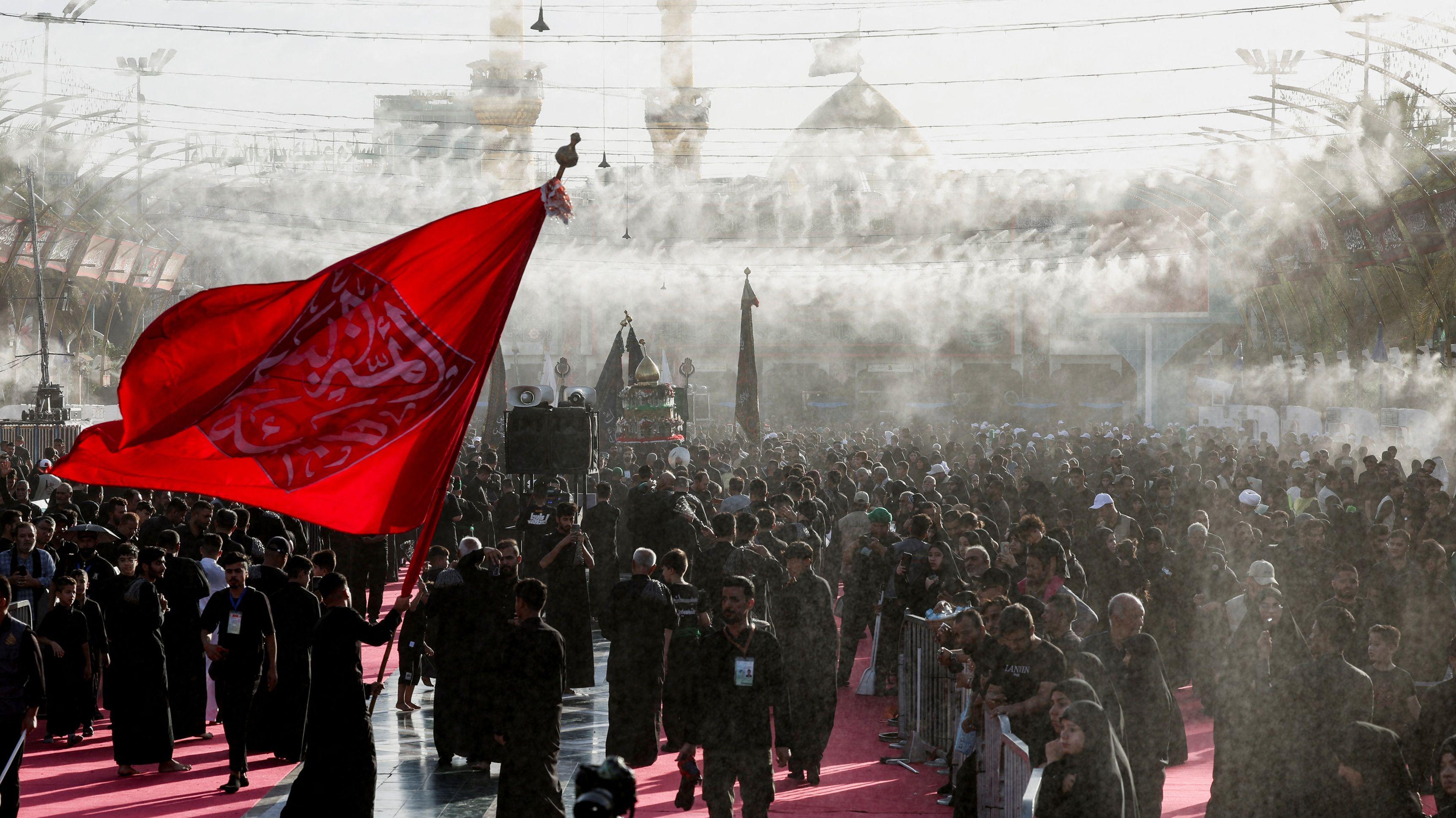 عاشوراء: لماذا يحيي الشيعة ذكرى مقتل الحسين وكيف تُقام طقوسها؟ 1 تجمع لمسلمين شيعة قبل عاشوراء أقدس الأيام الدينية عندهم في كربلاء في العراق وسط رش للماء للتبريد على وقع درجات حرارة مرتفعة