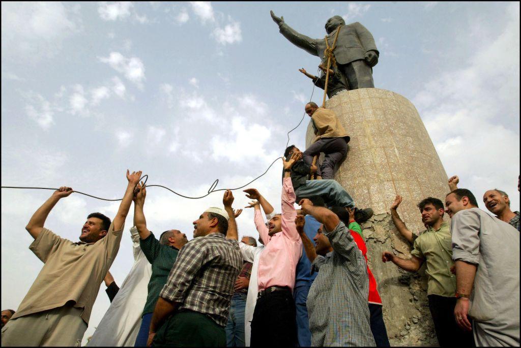 Pessoas derrubam est&aacute;tua de Saddam Hussein em Bagd&aacute;, Iraque.
