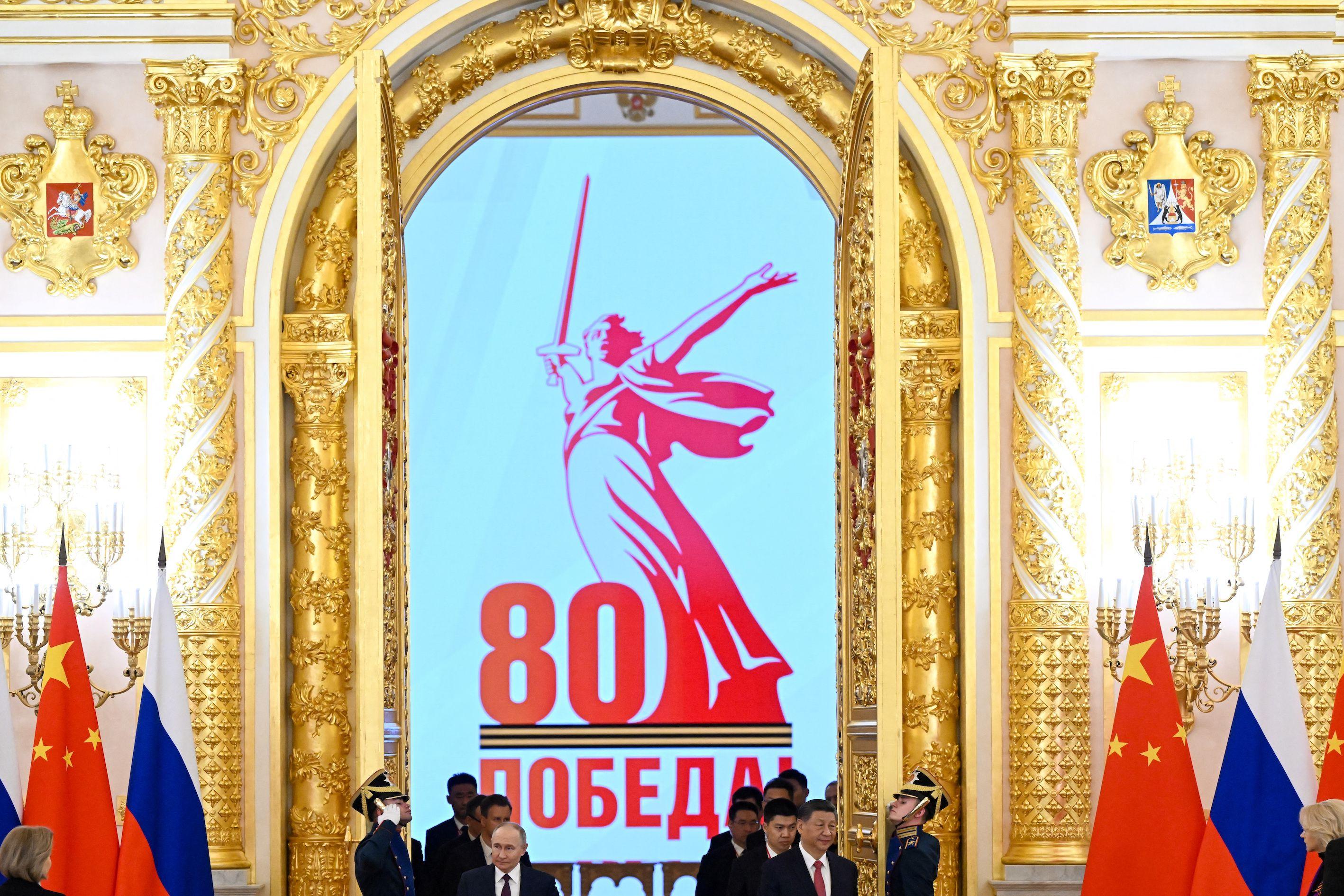 習近平和普京從一道金色的門兩側走進一個會場，兩旁有中國和俄羅斯的國旗。
