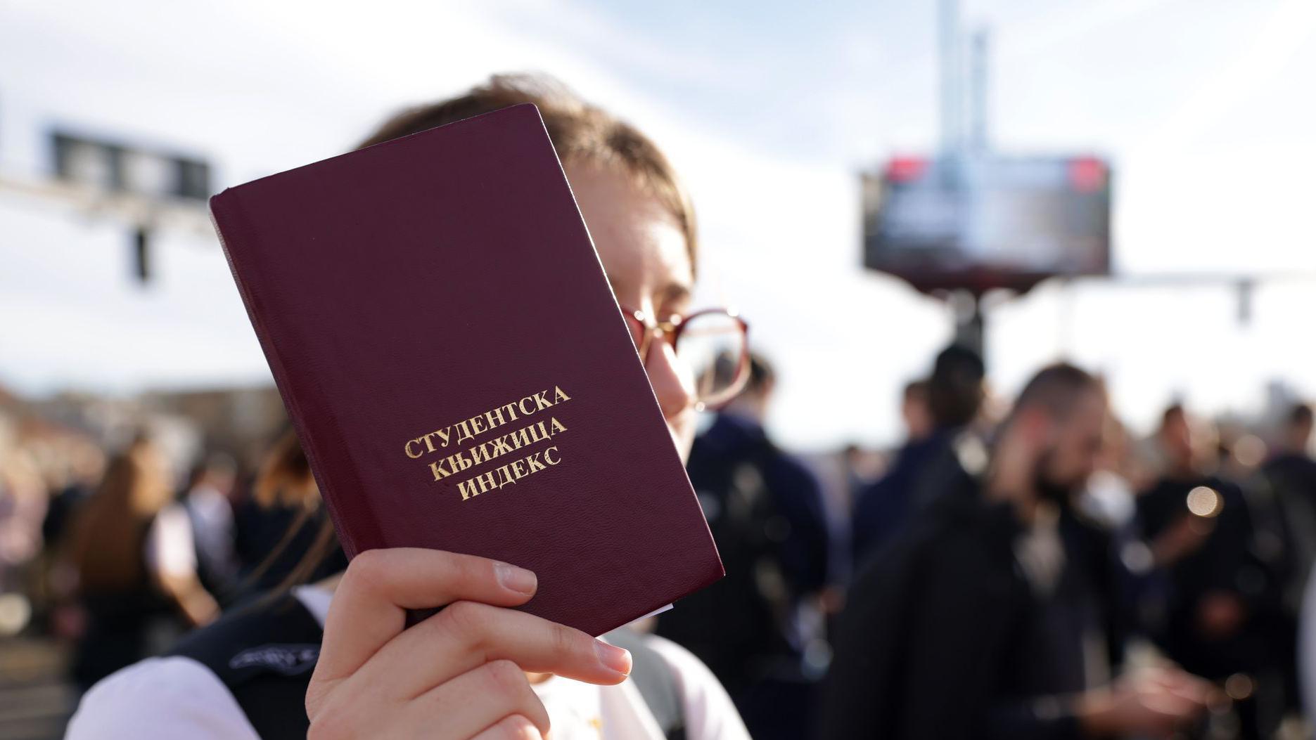 Devojka drži studentsku knjižicu
