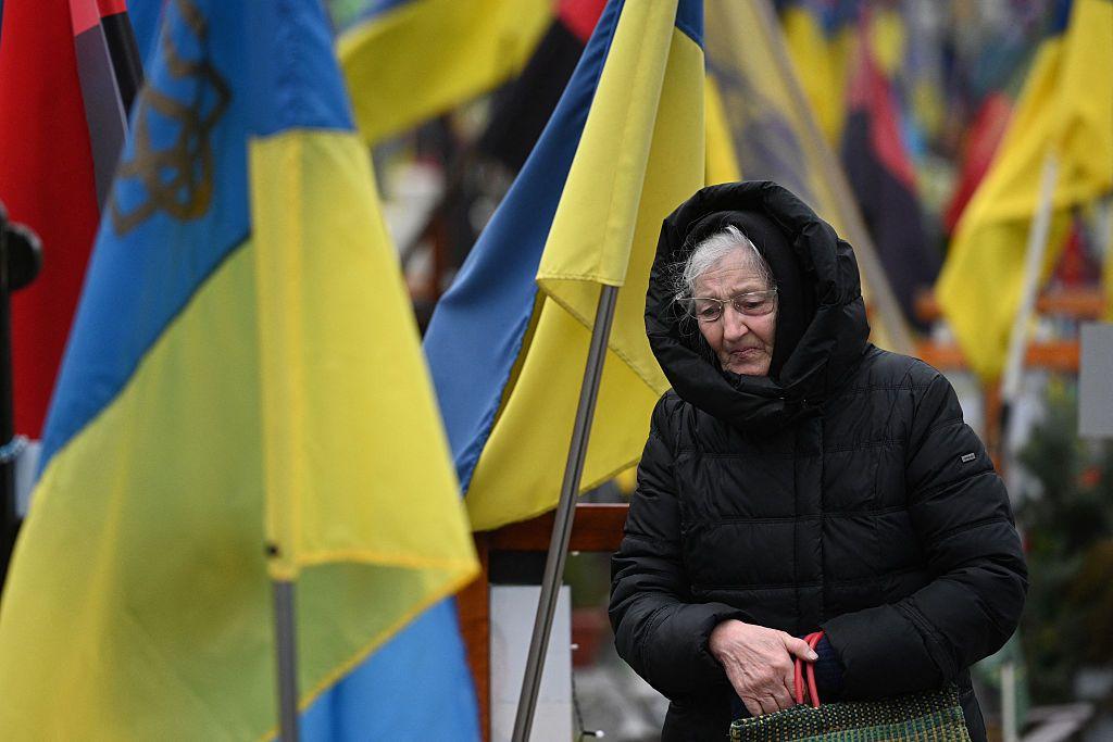 Uma mulher lamenta entre t&uacute;mulos de militares ucranianos no cemit&eacute;rio de Lychakiv
