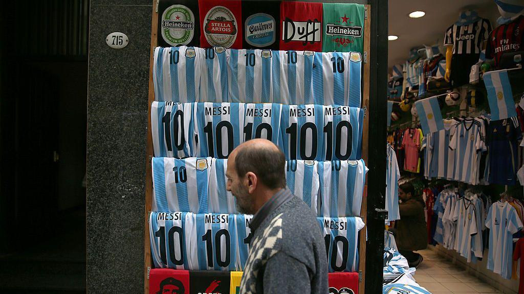 un hombre camina frente a una tienda de ropa en argentina. 