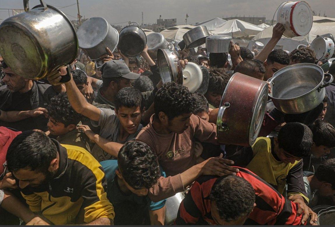 ازحون فلسطينيون يجمعون التبرعات الغذائية في جباليا، شمال غزة - 2 مايو 2025