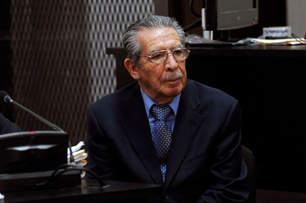 Efraín Ríos Montt, un hombre de edad, con bigote y anteojos, sentado en un tribunal durante un juicio