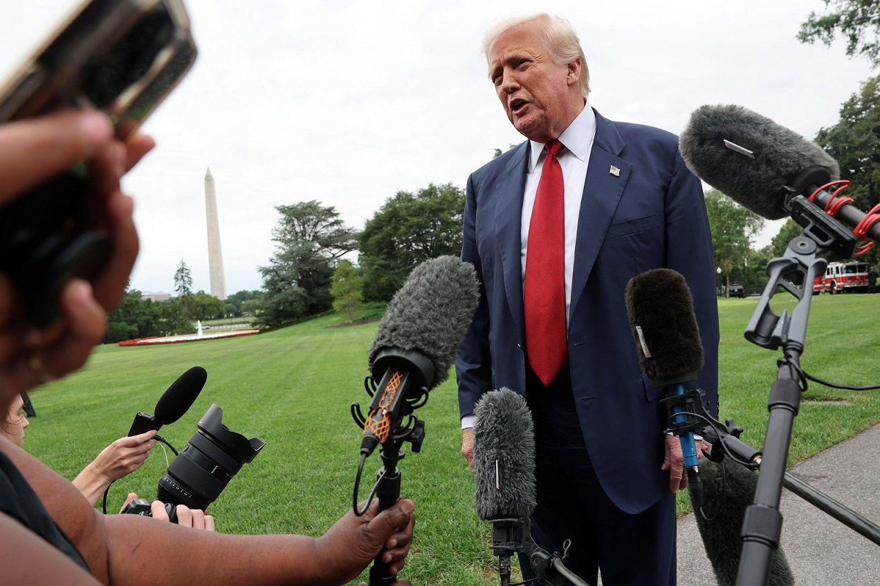 Trump em gramado, diante do microfone de repórteres