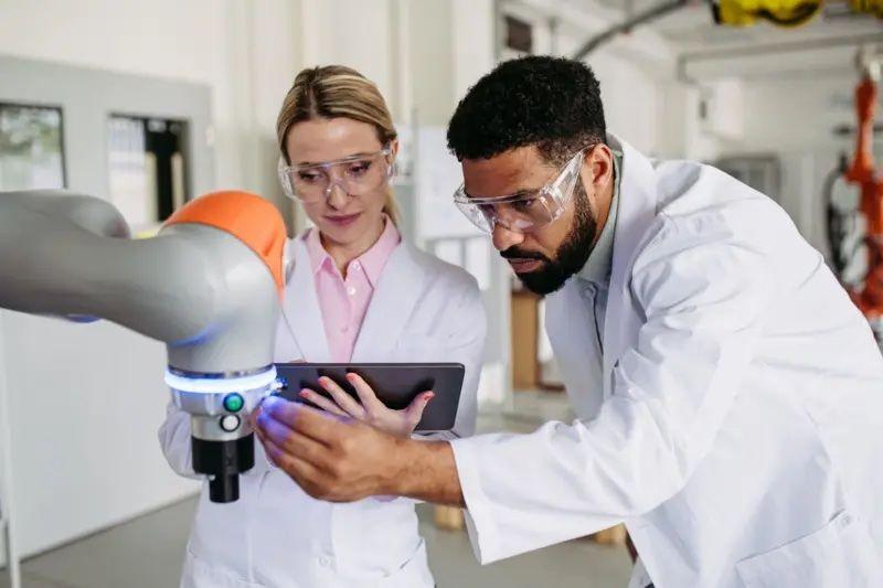 Duas pessoas vestidas de branco olhando uma máquina