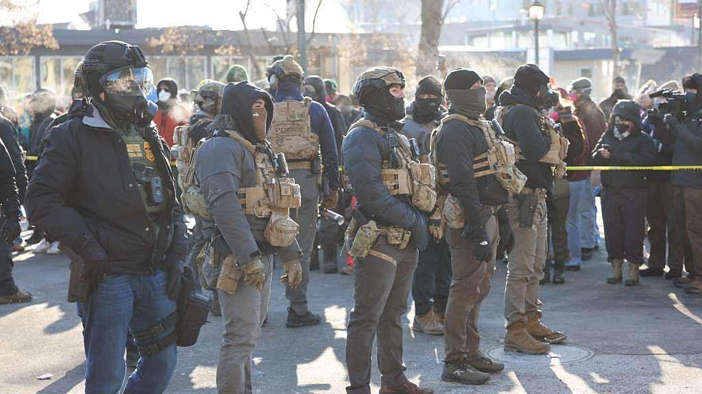 una fila de agentes del ice en mineápolis. la zona está acordonada luego del tiroteo. 