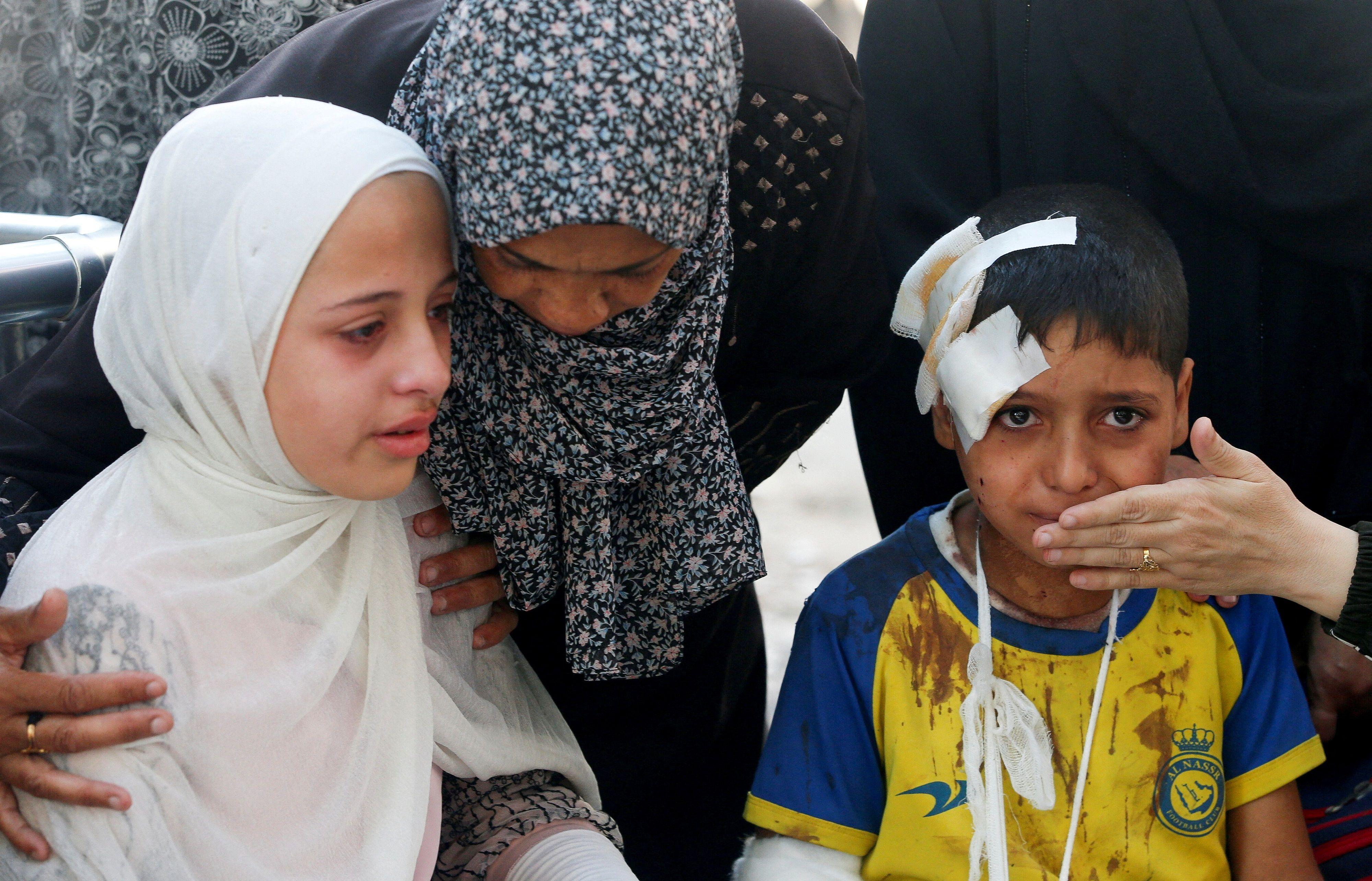 صبي مصاب وفتاة وسيدة خلال تشييع جنازة فلسطينيين قُتلوا بنيران إسرائيلية أثناء محاولتهم تلقي المساعدة وسط قطاع غزة، في مستشفى الشفاء بمدينة غزة، 24 يونيو/حزيران 2025
