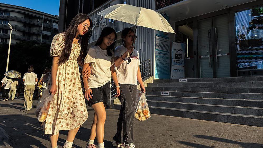 أشخاص يستظلون بمظلة