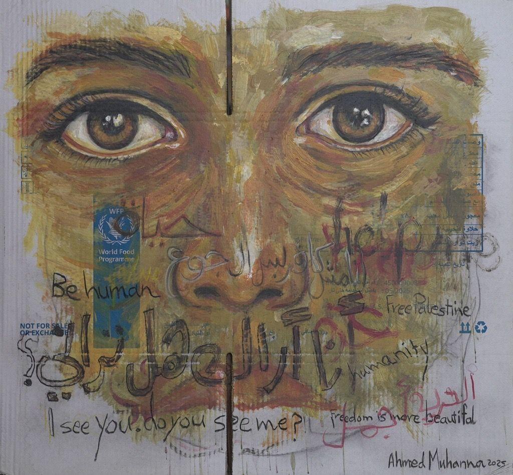 لوحة رسمها الفنان الفلسطيني أحمد مهنا، لوجه تبرز فيه عينان لونهما بين العسلي والأخضر ويغلب على الوجه اللون الأصفر . الرسم على كرتونة مساعدات. وكتب عليها جمل بالعربية والإنجليزية أبرزها سؤال "أنا أراك هل تراني؟". "أنا مش كافر بس الجوع كافر". "الحرية أجمل". "الحرية لفلسطين".