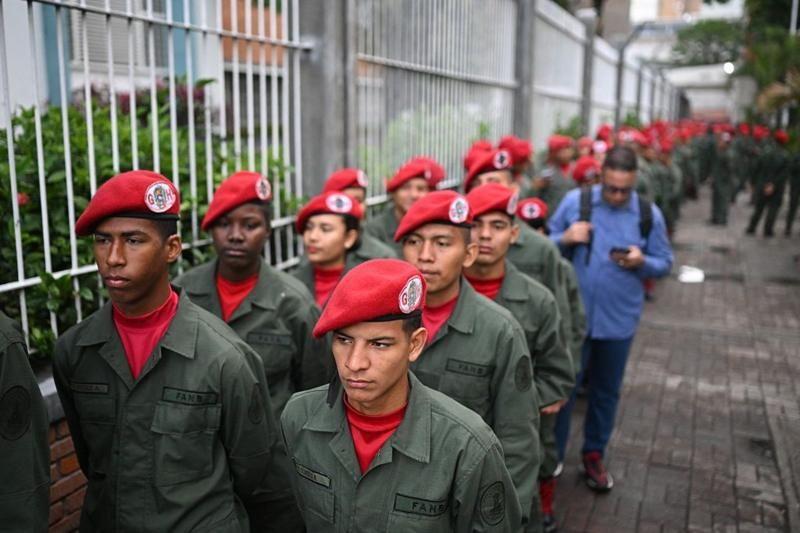 Guardas nacionais bolivarianos enfileirados, em um local de votação na Venezuela, em 25 de maio de 2025