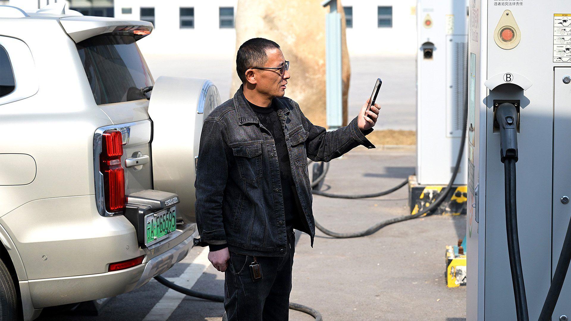 Un hombre cargando su camioneta eléctrica en China