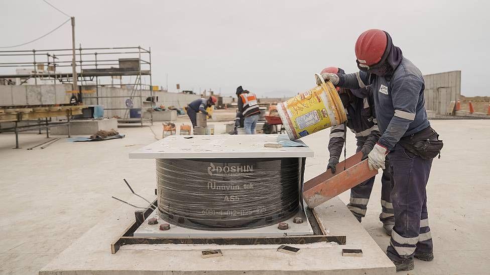 Trabajadores colocando aisladores sísmicos durante la construcción del nuevo terminal del aeropuerto internacional en Lima.