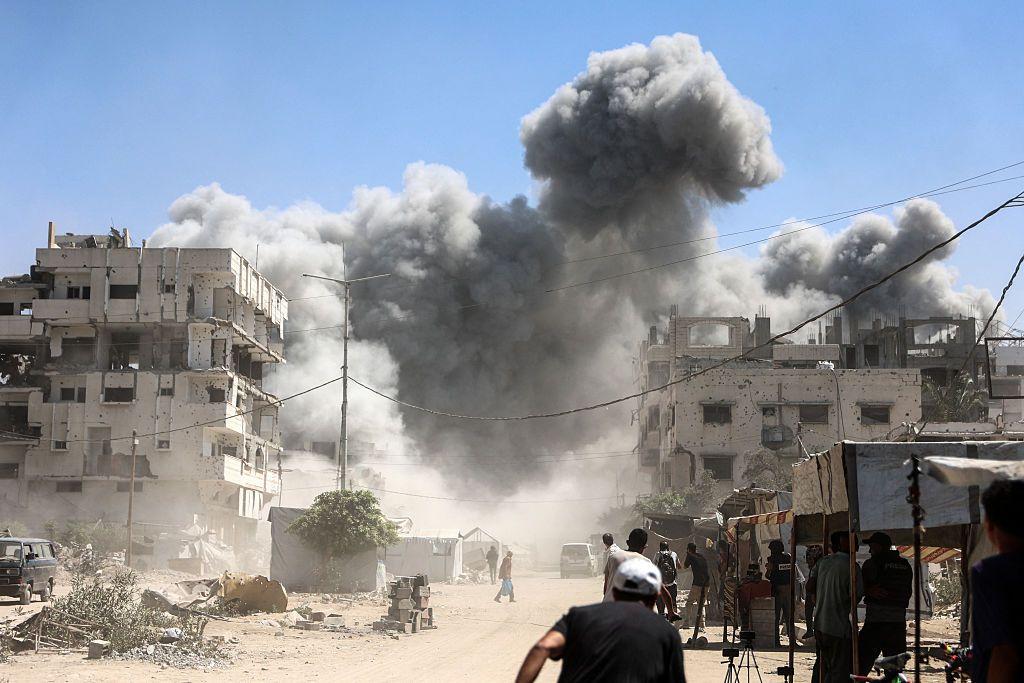 Palestinos cerca de un edifcio atacado.