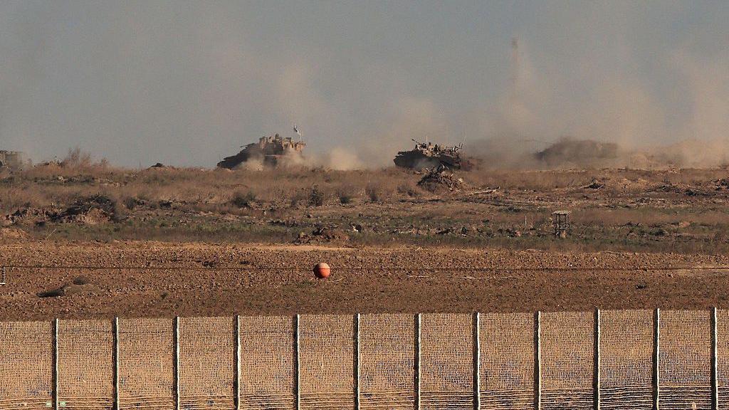دبابات إسرائيلية تتحرك على طول مسار في قطاع غزة، كما يُرى من موقع جنوبي، قرب السياج الحدودي بين إسرائيل وغزة.