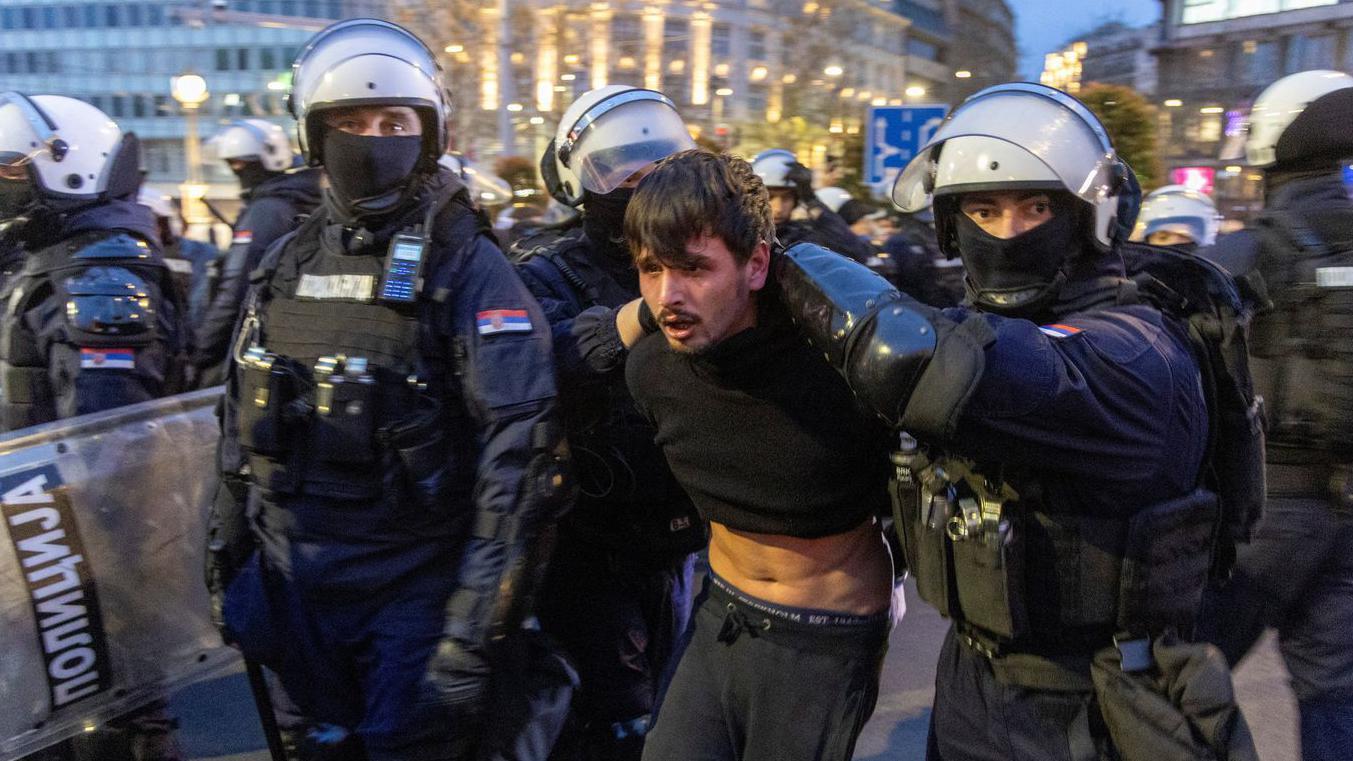 policajci u punoj opremi drže mladića 