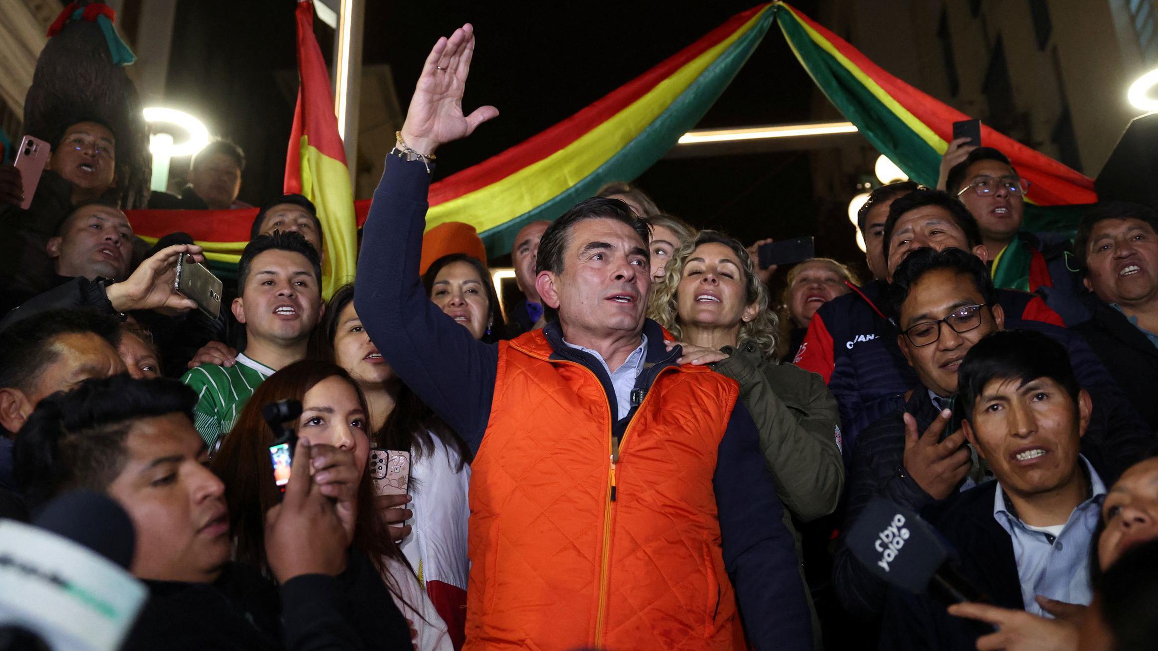 Rodrigo Paz con un chaleco rojo y rodeado de partidarios