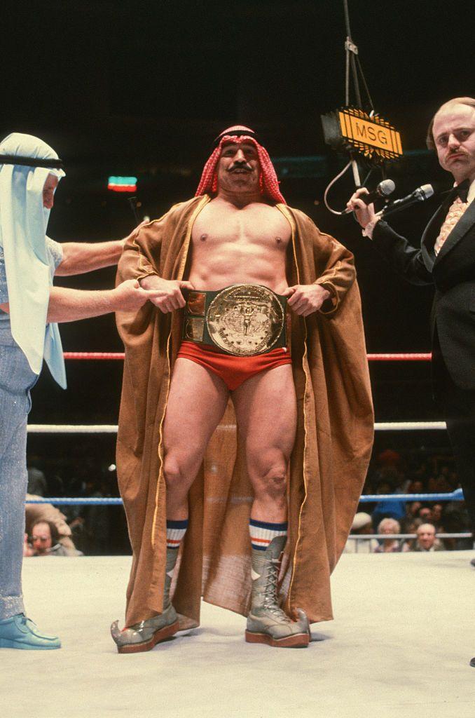 El Jeque de Hierro posa con el título mundial de lucha libre.